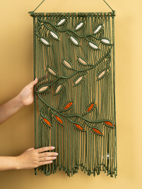 Macrame wall hanging with leaf patterns on a yellow background
