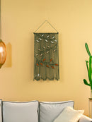 Decorative wall hanging with beads on a yellow wall above a sofa.