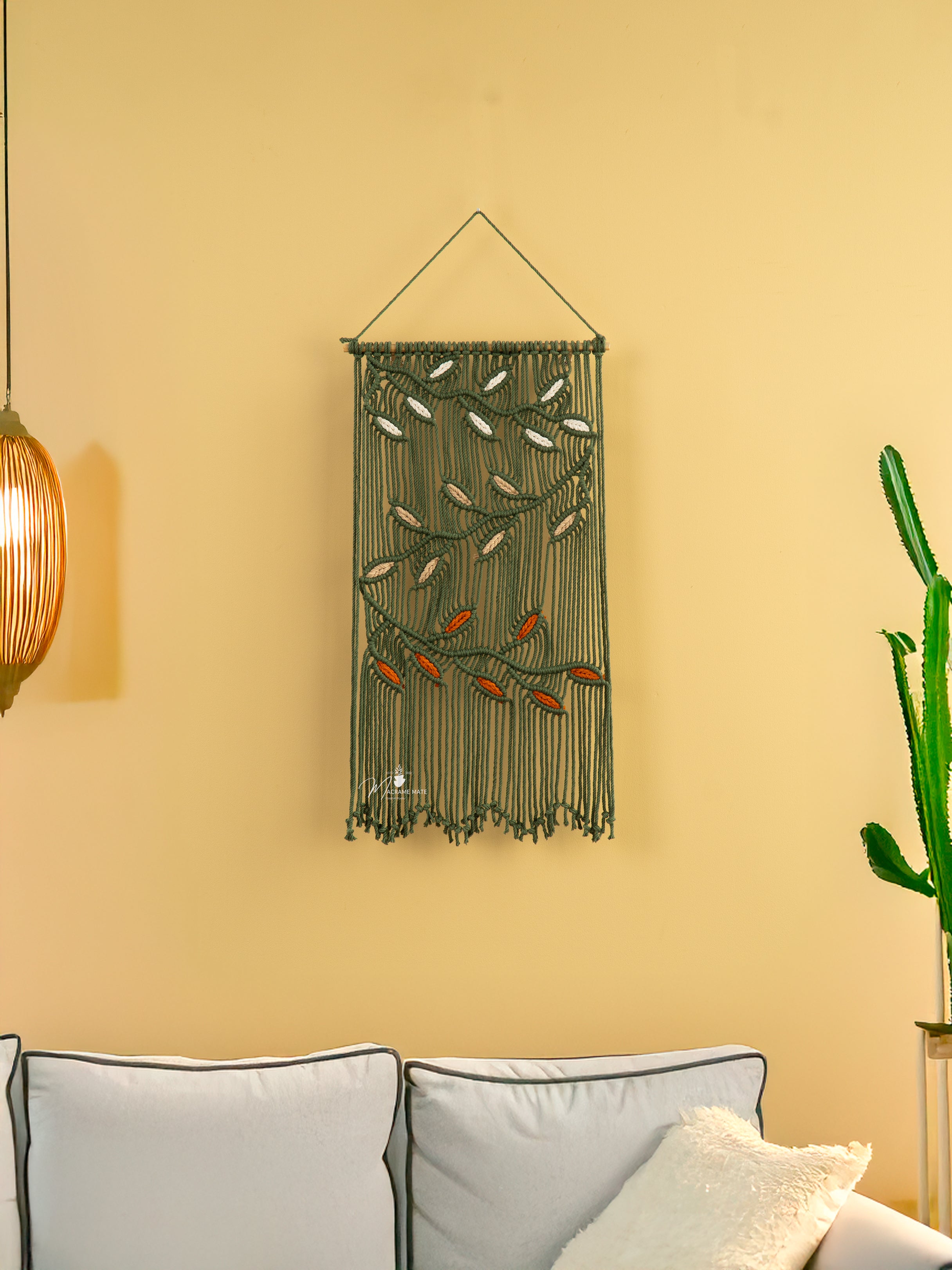 Decorative wall hanging with beads on a yellow wall above a sofa.