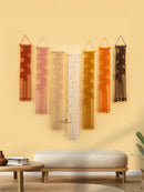 Set of decorative wall hangings on a beige wall with a bench and coffee table in the foreground.