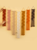 Set of macrame wall hangings in various colors on a beige background