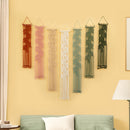 Set of six string art wall decorations on a yellow wall with a green sofa and lamp in the foreground.