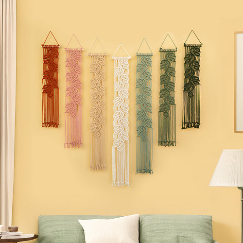 Set of six string art wall decorations on a yellow wall with a green sofa and lamp in the foreground.