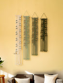 Four wall hangings with different patterns on a yellow wall.