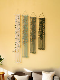 Four wall hangings with different patterns on a yellow wall.